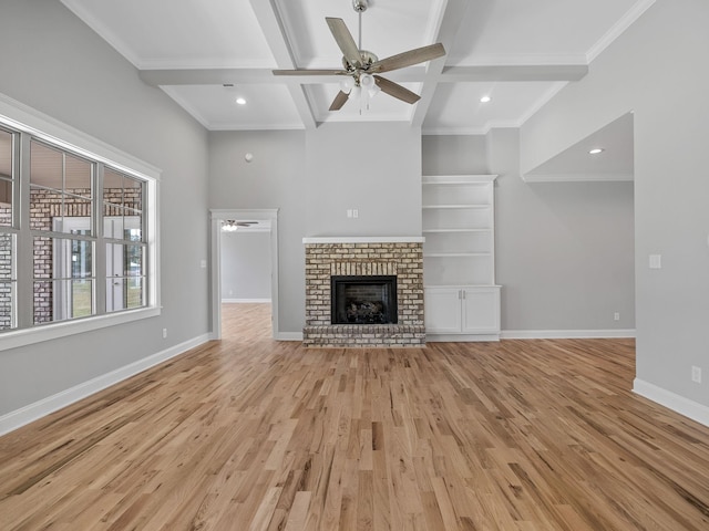 unfurnished living room with light wood-type flooring, a brick fireplace, ceiling fan, coffered ceiling, and beam ceiling