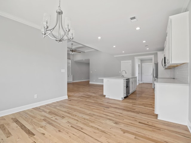 kitchen featuring white cabinets, hanging light fixtures, a kitchen island with sink, and light wood-type flooring