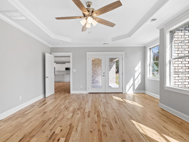 interior space featuring crown molding, light wood-type flooring, and a raised ceiling