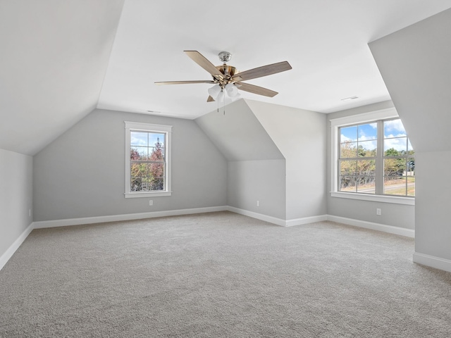 additional living space with ceiling fan, light colored carpet, and vaulted ceiling