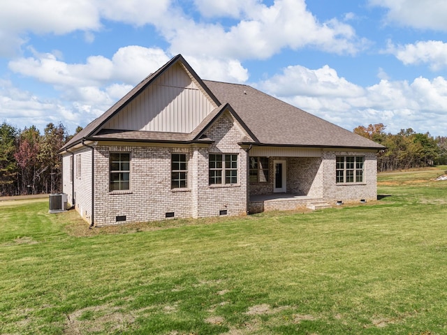 rear view of house with a yard and central AC unit