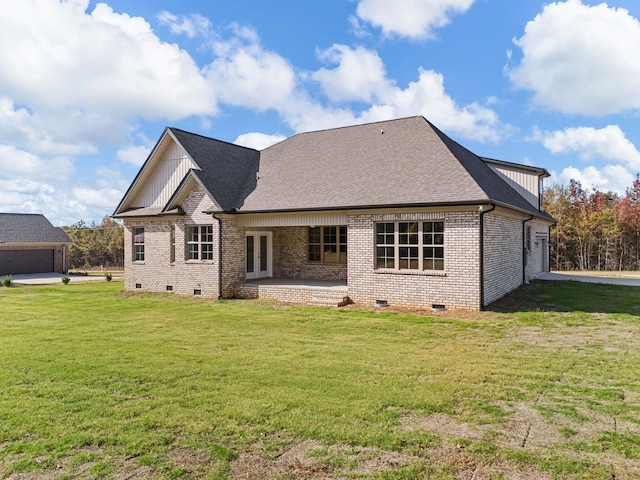 back of property with a yard and a garage