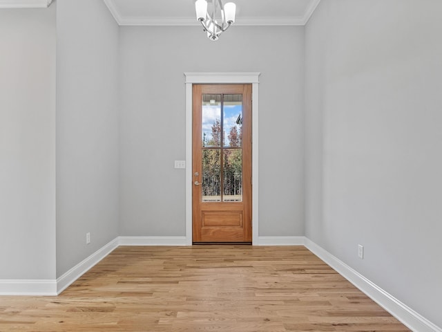 unfurnished room featuring crown molding, light hardwood / wood-style flooring, and an inviting chandelier