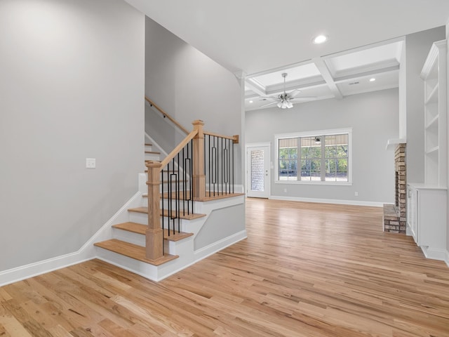 stairway featuring beam ceiling, hardwood / wood-style flooring, coffered ceiling, and ceiling fan