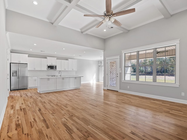 unfurnished living room featuring light hardwood / wood-style flooring, ornamental molding, beamed ceiling, and ceiling fan with notable chandelier