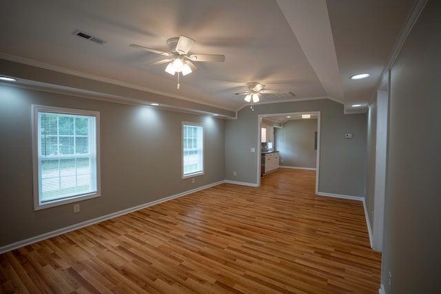 empty room with light hardwood / wood-style floors, ornamental molding, and ceiling fan