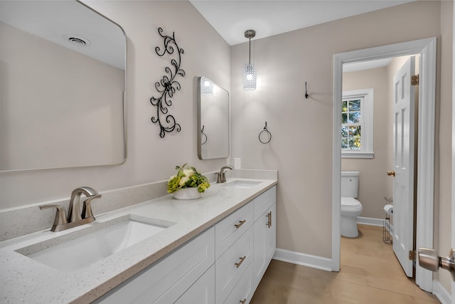 bathroom featuring toilet, vanity, and tile patterned flooring