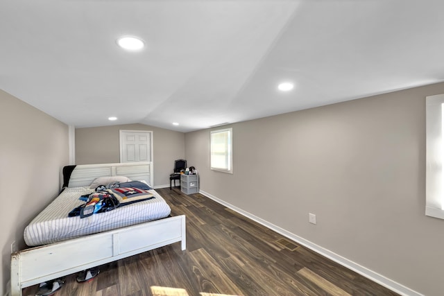 bedroom with vaulted ceiling and dark hardwood / wood-style flooring