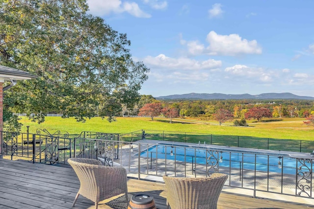 view of pool with a yard and a deck with mountain view