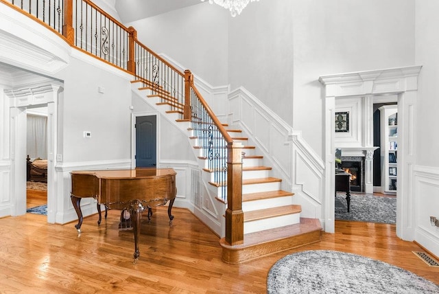 stairway featuring wood-type flooring and a high ceiling