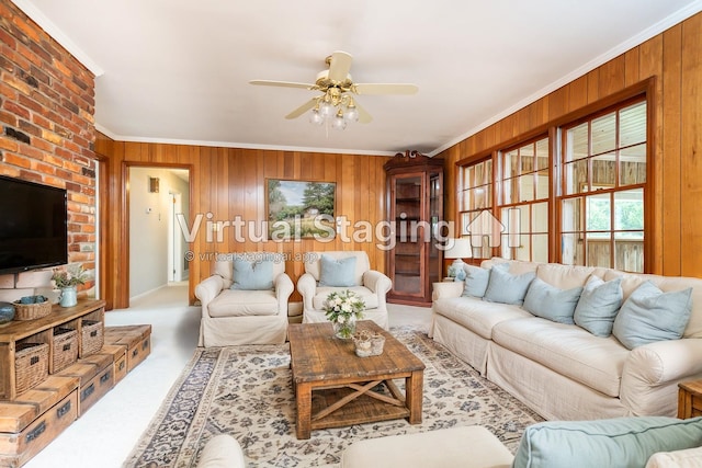 carpeted living room with crown molding, ceiling fan, and wooden walls