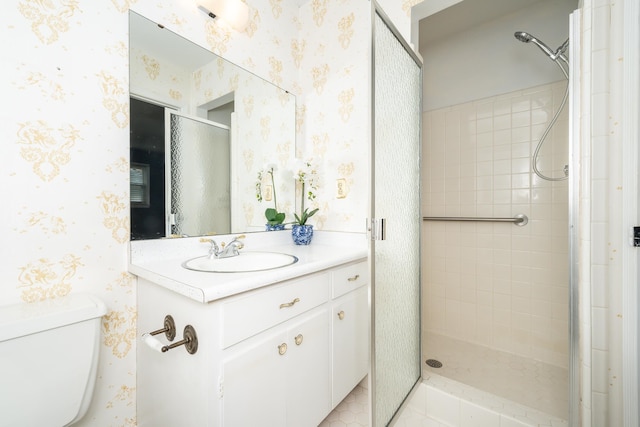 bathroom featuring toilet, vanity, a tile shower, and tile patterned floors