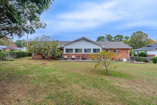 rear view of property featuring a lawn