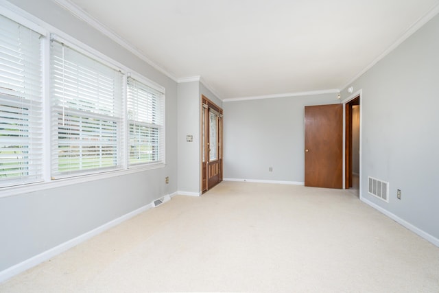 unfurnished room with ornamental molding and light colored carpet