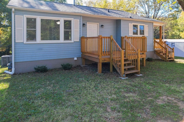 back of property featuring central AC, a deck, and a lawn