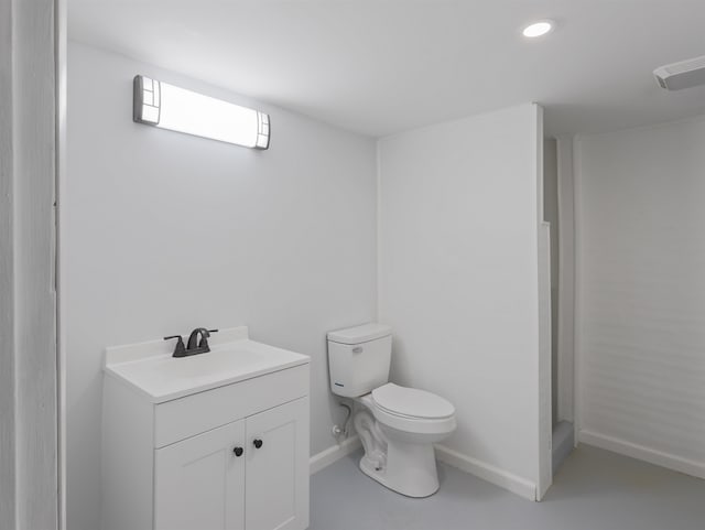 bathroom featuring vanity, concrete flooring, and toilet