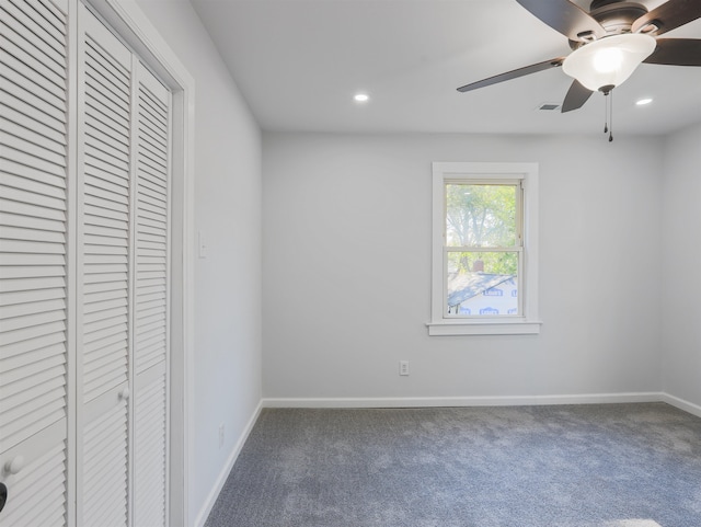 unfurnished bedroom featuring a closet, dark carpet, and ceiling fan