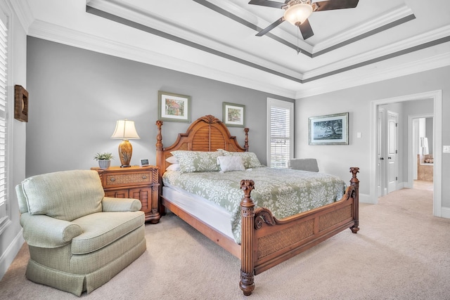 bedroom featuring light carpet, crown molding, a tray ceiling, and ceiling fan