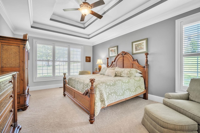 carpeted bedroom with ornamental molding, a tray ceiling, and ceiling fan