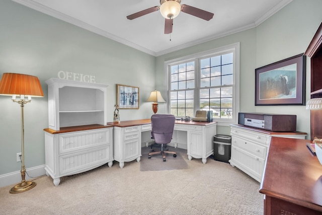 carpeted office space featuring built in desk, crown molding, and ceiling fan