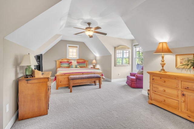 bedroom with vaulted ceiling, light carpet, multiple windows, and ceiling fan