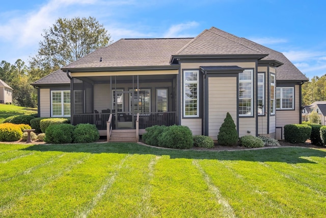 rear view of property with a yard and a sunroom