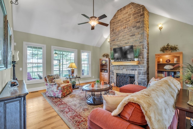 living room featuring light hardwood / wood-style floors, high vaulted ceiling, a fireplace, and ceiling fan