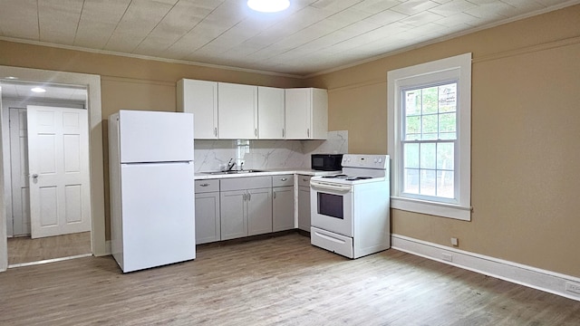 kitchen featuring white appliances, sink, white cabinetry, crown molding, and light hardwood / wood-style flooring