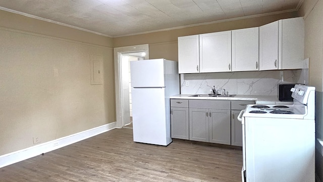 kitchen featuring white appliances, ornamental molding, sink, white cabinets, and light hardwood / wood-style floors