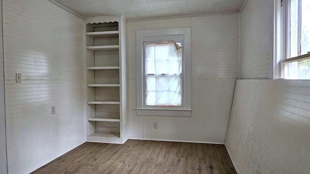 spare room with dark wood-type flooring and built in features