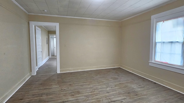 unfurnished room featuring dark wood-type flooring and crown molding