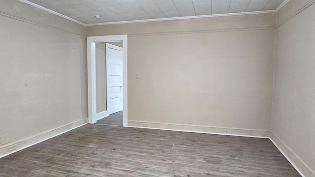 unfurnished room with ornamental molding and dark wood-type flooring