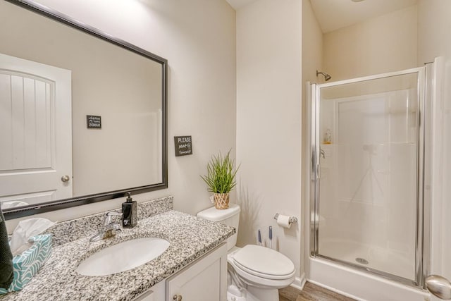 bathroom featuring toilet, an enclosed shower, and vanity