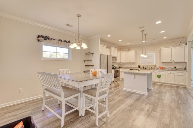 dining room featuring crown molding, light hardwood / wood-style flooring, and a chandelier