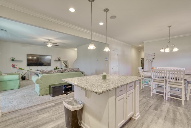 kitchen featuring a center island, light hardwood / wood-style flooring, pendant lighting, and white cabinets