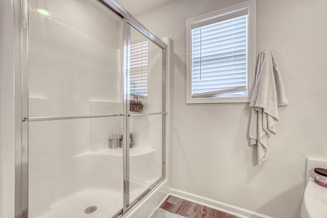 bathroom featuring a shower with door and hardwood / wood-style floors