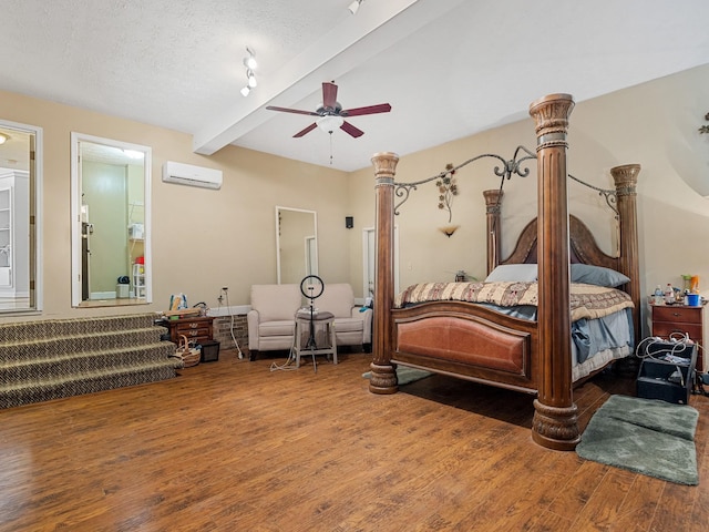 bedroom featuring a textured ceiling, ceiling fan, beamed ceiling, a wall unit AC, and hardwood / wood-style flooring