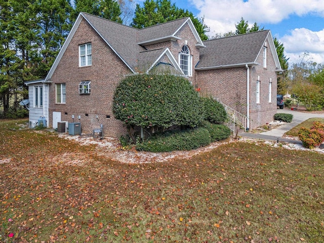 view of side of property with central AC and a lawn