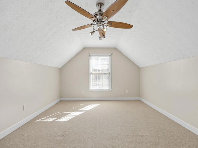 additional living space with lofted ceiling, ceiling fan, a textured ceiling, and carpet flooring