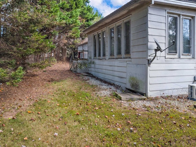 view of home's exterior with a wooden deck and a lawn