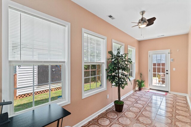 doorway featuring light tile patterned floors and ceiling fan