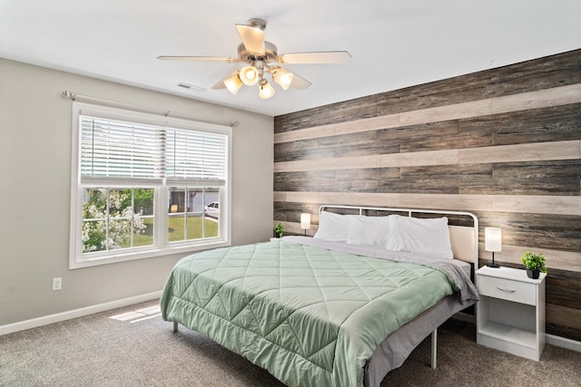 carpeted bedroom with wooden walls and ceiling fan