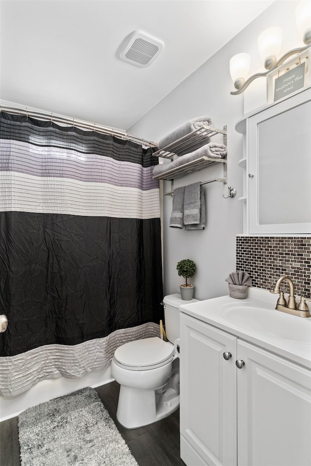 bathroom featuring toilet, wood-type flooring, curtained shower, vanity, and tasteful backsplash