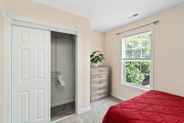 bedroom featuring light colored carpet and a closet