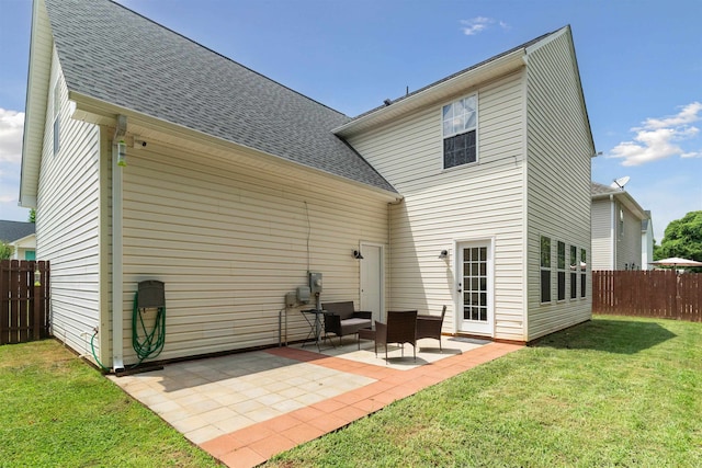 back of property with a patio and a lawn