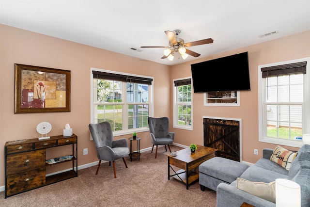 living room featuring ceiling fan, carpet, plenty of natural light, and a fireplace