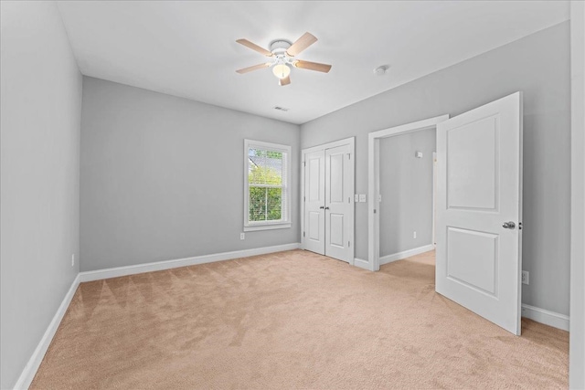 unfurnished bedroom featuring light carpet and ceiling fan