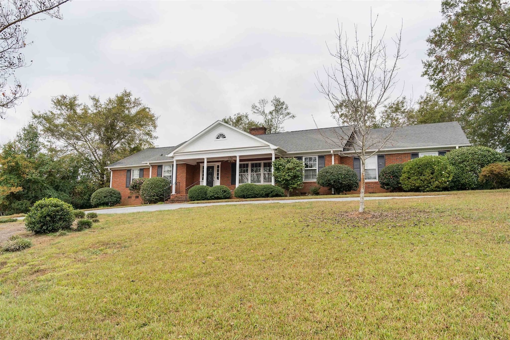 view of front of house featuring a porch and a front lawn