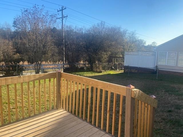 wooden deck featuring a lawn