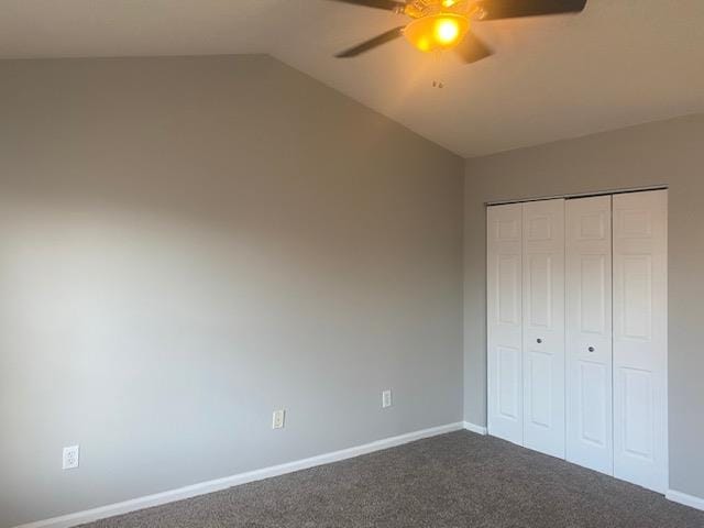 unfurnished bedroom with a closet, ceiling fan, lofted ceiling, and dark colored carpet